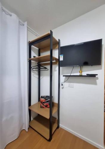 a room with a tv and a shelf with a television at Conforto e paz de Ramos in Rio de Janeiro