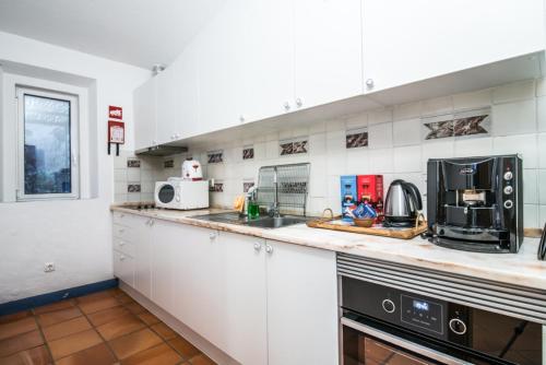 a kitchen with white cabinets and a counter top at Casas de Juromenha in Juromenha