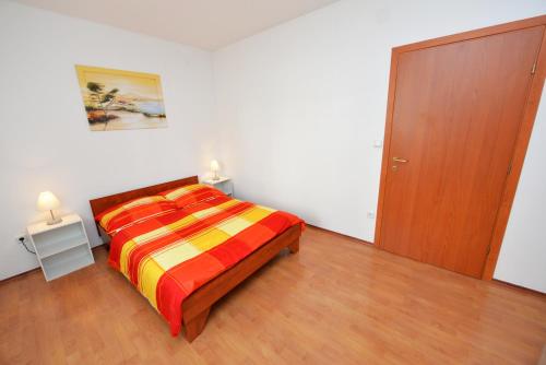 sypialnia z łóżkiem i drewnianymi drzwiami w obiekcie Apartment Dadi w Novalji