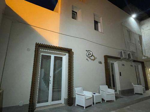 a room with white chairs and a building at Lazzara 19 in Marsala