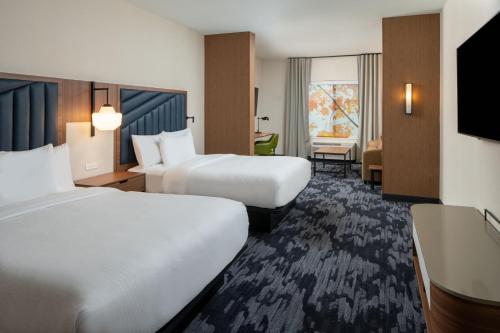 a hotel room with two beds and a television at Fairfield by Marriott Inn & Suites Southaven Snowden Grove in Southaven