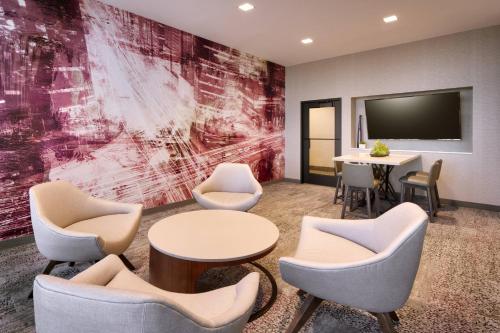 a waiting room with chairs and a table and a tv at Courtyard by Marriott Cedar City in Cedar City