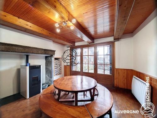 - un salon avec une table en bois et une table à manger dans l'établissement Chez Jojo, à Chambon-sur-Lac