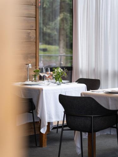 a table with a white table cloth and flowers on it at Hôtel Restaurant Spa Les Jardins De Sophie in Xonrupt-Longemer