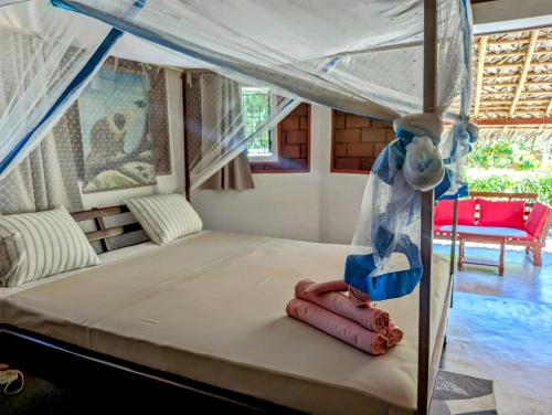 a bedroom with a bed with a canopy at Hotel Lakana Ramena in Diego Suarez