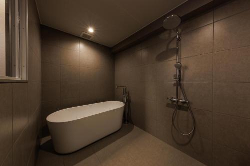 a bathroom with a bath tub and a shower at villa one in Kaizu