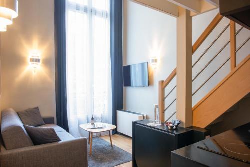 a living room with a couch and a table at Hôtel Helzear Etoile in Paris