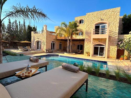a house with a swimming pool in front of a house at Palais Babel in Essaouira