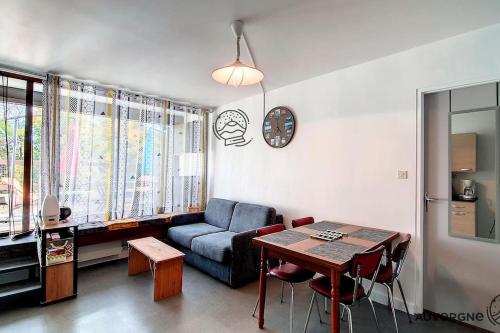 un salon avec un canapé bleu et une table dans l'établissement Le Bol d'Air, à Murol