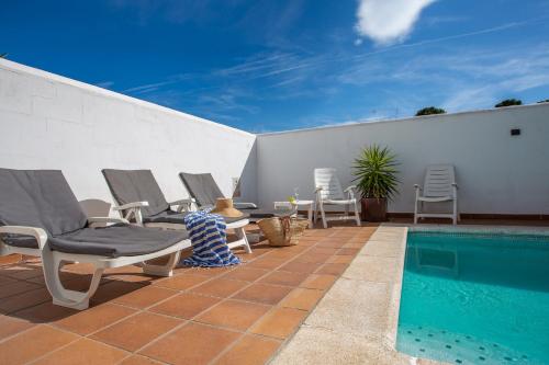 a patio with chairs and a swimming pool at Casa Alexandra in L'Escala