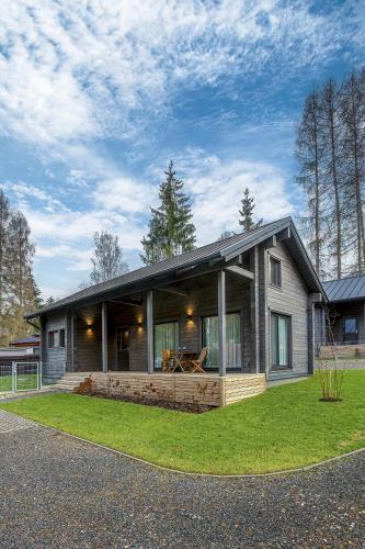 a small house with a large porch on the grass at Finskä chata in Samopše