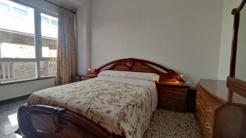ein Schlafzimmer mit einem Bett, einer Kommode und einem Fenster in der Unterkunft Apartamento Mirador de Cee in Cee