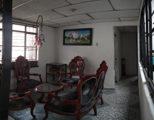 a room with chairs and a table and a picture on the wall at My second house in Manizales