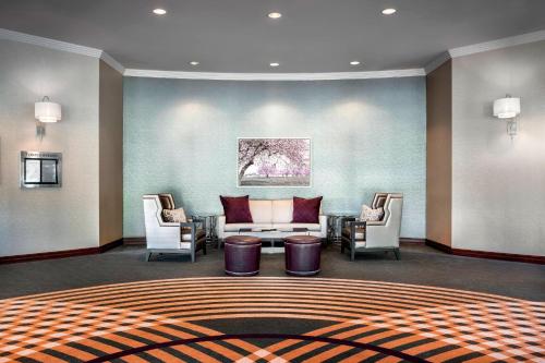 a living room with a couch and two chairs at Sheraton Toronto Airport Hotel & Conference Centre in Toronto