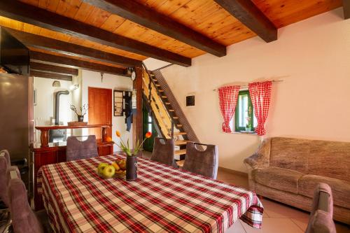 a dining room with a table and a couch at Woodland Retreat in Donji Zagon