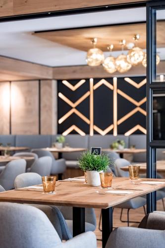 a wooden table in a restaurant with chairs at Ruhpoldinger Hof - Hotel & Wellness in Ruhpolding