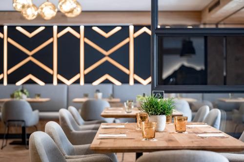 a dining room with tables and chairs and a tv at Ruhpoldinger Hof - Hotel & Wellness in Ruhpolding