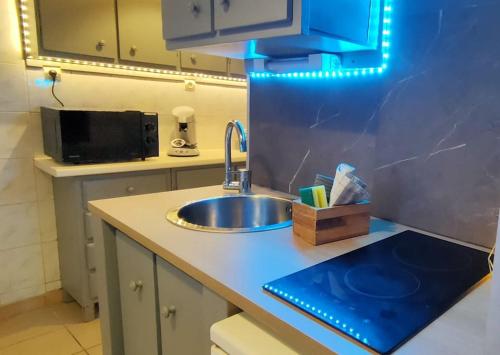 un comptoir de cuisine avec un évier et un micro-ondes dans l'établissement Maisonnette parking moto au cœur des sables, à Berck-sur-Mer