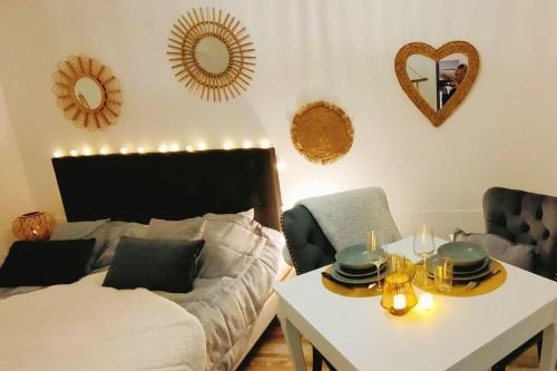 un salon avec un lit, une table et des miroirs dans l'établissement Maisonnette parking moto au cœur des sables, à Berck-sur-Mer