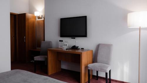 a hotel room with a desk with two chairs and a television at Hotel 4x4 in Rivne