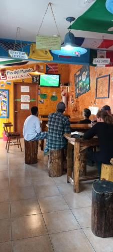a group of people sitting at tables in a restaurant at Hostel Cruz del Sur in Ushuaia
