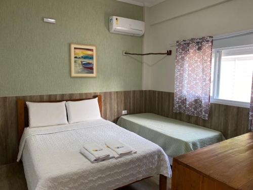a bedroom with a bed with two towels on it at Residencial Águas de Bare in São Sebastião