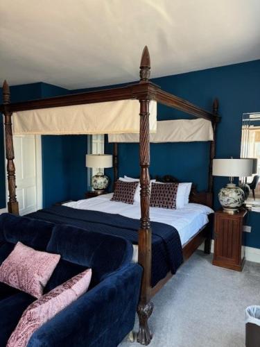 a bedroom with a canopy bed and a couch at Abbey View House in Youghal