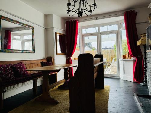a living room with a table and a couch and a window at Central City Centre 3 bedroom home Private Parking in Plymouth