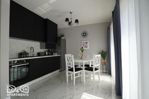 une cuisine avec une table blanche et des chaises dans l'établissement Pine Tree House 6 D&D Apartments, à Międzywodzie