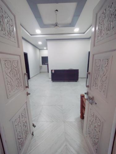 an empty room with two doors and a projection screen at Hotel seafront in Murud