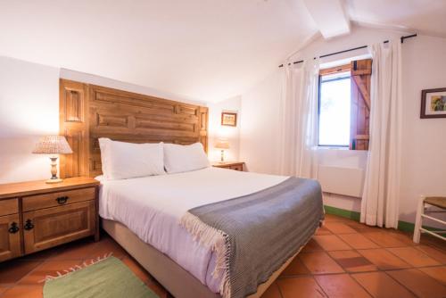 a bedroom with a large bed and a window at Casas de Juromenha in Juromenha