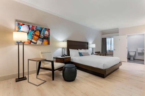 a bedroom with a bed and a desk and a chair at Best Western Plus All Suites Inn in Santa Cruz