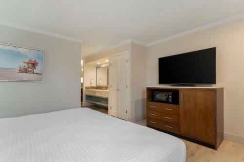 a bedroom with a bed and a flat screen tv at Best Western Plus All Suites Inn in Santa Cruz