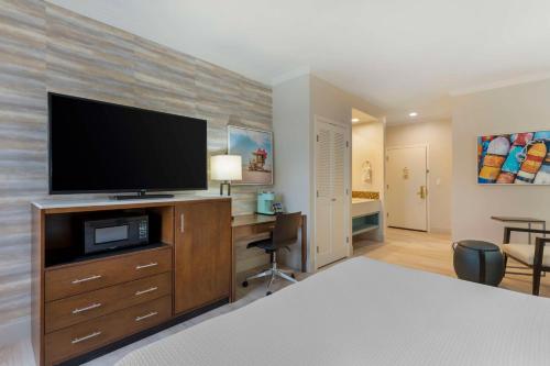 a bedroom with a flat screen tv on a dresser at Best Western Plus All Suites Inn in Santa Cruz