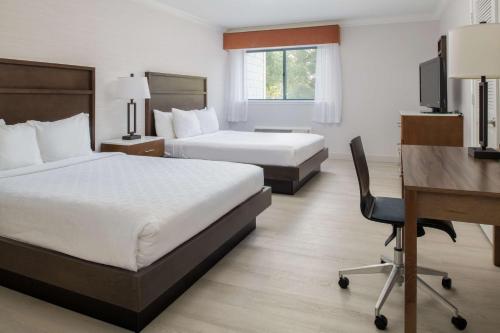 a hotel room with two beds and a desk at Best Western Plus All Suites Inn in Santa Cruz