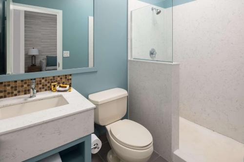 a bathroom with a toilet and a sink and a shower at Best Western Plus All Suites Inn in Santa Cruz