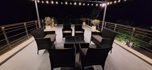a table and chairs on a balcony at night at Pool Villa Happiness Lush Valley in Ban Bung Toei