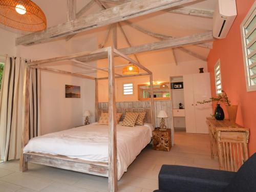 a bedroom with a canopy bed in a room at La Villa de la Plage in La Saline les Bains