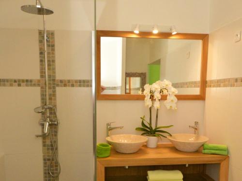 a bathroom with two sinks and a mirror and a shower at La Villa de la Plage in La Saline les Bains