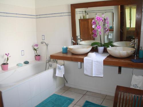a bathroom with three sinks and a bath tub at La Villa de la Plage in La Saline les Bains