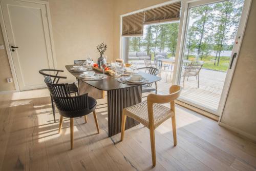a dining room with a table and chairs and a patio at Modern boende med sjöutsikt in Ryssby