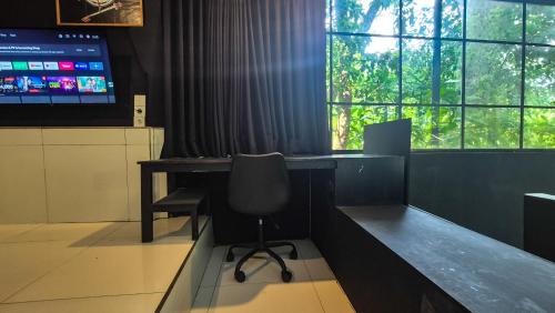 an office with a desk with a chair and a monitor at The Paica in Denpasar