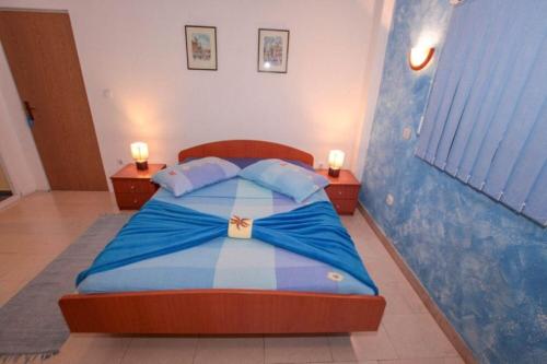 1 dormitorio con 1 cama azul y blanca y 2 mesitas de noche en Apartments Drago, en Klek