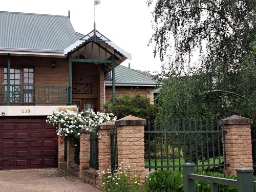 a house with a gate and a fence with flowers at Clarens Mount Rose self-catering holiday house in Clarens