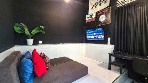 a living room with a couch with red and blue pillows at The Paica in Denpasar
