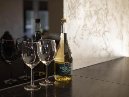 two bottles of wine sitting on a table with wine glasses at Modern boende med sjöutsikt in Ryssby