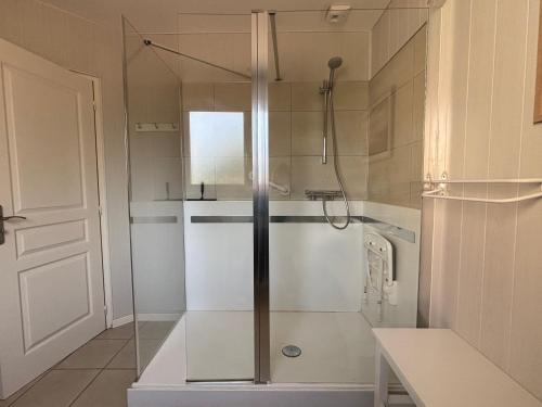 une douche avec une porte vitrée dans une salle de bain dans l'établissement La clé des champs Maison plain pied spacieuse lumineuse bien équipée, 3 chambres spacieuse, belle terrasse aménagée, garage, grand jardin clos, parking, près de Bayeux et Omaha Beach, à Tour-en-Bessin