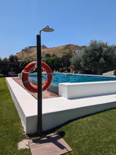 a swimming pool with a red life preserver at Casas de Juromenha in Juromenha