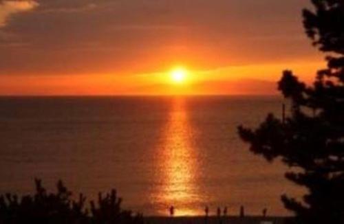 a sunset over the ocean with the sun in the sky at Kizuna House Yuzuriha in Minamiawaji