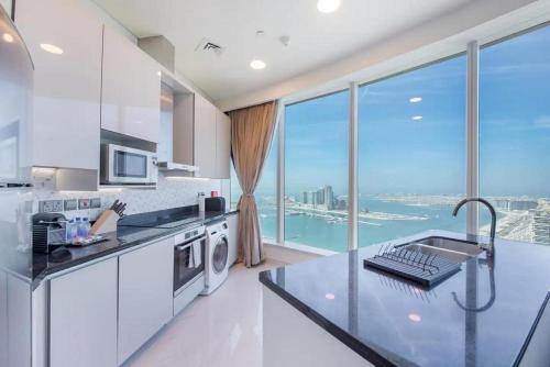 a kitchen with white appliances and a large window at GLOBALSTAY Palm View in Dubai